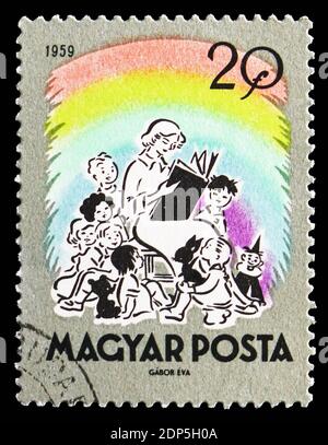 MOSKAU, RUSSLAND - 15. SEPTEMBER 2018: Eine in Ungarn gedruckte Briefmarke zeigt den Lehrer beim Lesen von Märchen, Serie, um 1959 Stockfoto