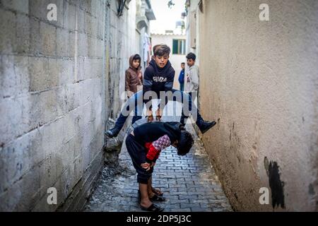 Gaza, Der Gazastreifen, Palästina. Dezember 2020. Palästinensische Kinder spielen Hochsprung vor ihrem Haus im Lager Jabalia im nördlichen Gazastreifen. Quelle: Mahmoud Issa/SOPA Images/ZUMA Wire/Alamy Live News Stockfoto