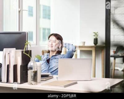 Junge asiatische Geschäftsfrau arbeitet im Büro mit Desktop-Computer Stockfoto