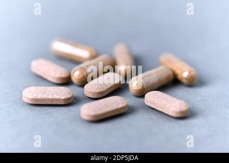 Ashwagandha (Withania somnifera) Tabletten und Kapseln auf Papier Hintergrund. Nahaufnahme. Stockfoto