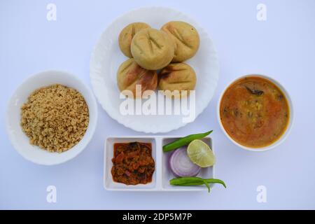 Rajasthani Indische Küche thaali Kombination von Dal Baati Churma, Tomate Chutney und Zwiebel grünlich Sala mit weißem Hintergrund. Weizenmehl Stockfoto