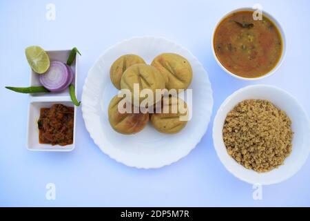 Rajasthani Indische Küche thaali Kombination von Dal Baati Churma, Tomate Chutney und Zwiebel grünlich Sala mit weißem Hintergrund. Weizenmehl Stockfoto