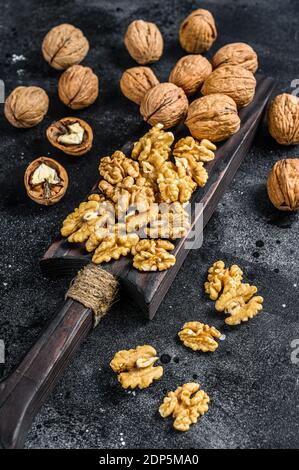 Geschälte Walnüsse Kerne auf Holz Schneidebrett. Schwarzer Hintergrund. Draufsicht. Stockfoto