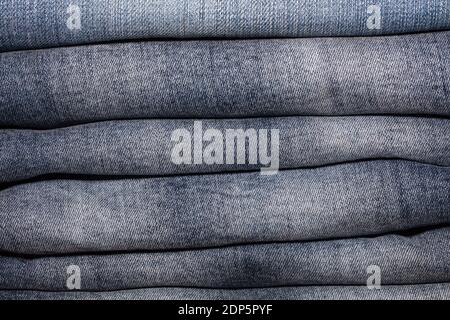 Nahaufnahme eines Stapels gefalteter weißer Jeans im Modegeschäft. Konzepte der Einkaufs- und Bekleidungsindustrie. Stockfoto