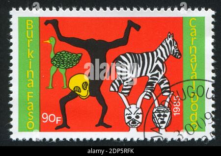 BURKINA FASO - UM 1985: Briefmarke gedruckt von Burkina Faso, zeigt Zebra, Strauß, Tänzer, um 1985 Stockfoto