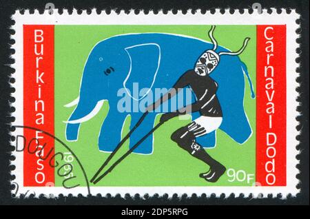 BURKINA FASO - UM 1985: Briefmarke gedruckt von Burkina Faso, zeigt Elefant, Tänzer, um 1985 Stockfoto