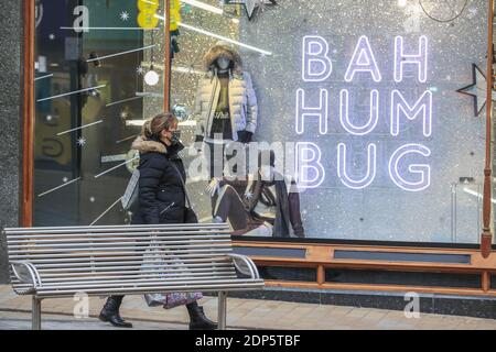 Ein Shopper am frühen Morgen geht an einem Schild vorbei, auf dem ‘Bah steht Humbug’ in Leeds City Centre als zweitnationale des Landes Sperrbeschränkungen enden und fallen auf Stufe 3 in West Yorkshire Stockfoto