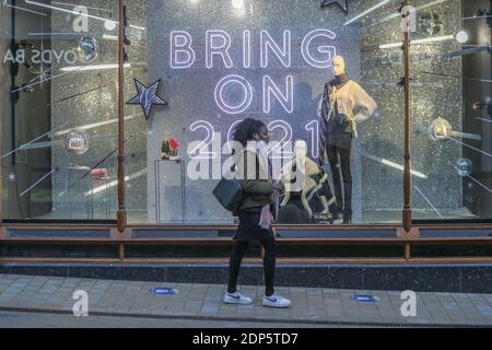 Ein Shopper am frühen Morgen geht an einem Schild vorbei, auf dem ‘Bring steht Am 2021’ in Leeds City Centre als zweite des Landes Nationale Sperrbeschränkungen enden und fallen auf Stufe 3 in West Yorkshire Stockfoto