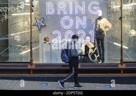 Ein Shopper am frühen Morgen geht an einem Schild vorbei, auf dem ‘Bring steht Am 2021’ in Leeds City Centre als zweite des Landes Nationale Sperrbeschränkungen enden und fallen auf Stufe 3 in West Yorkshire Stockfoto