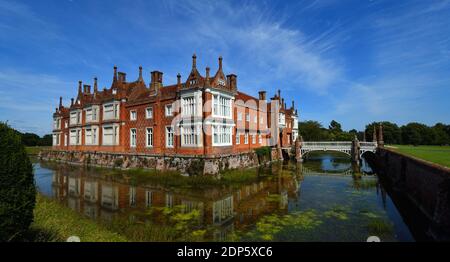 Helmingham Hall mit Graben Brücke und Reflexionen. Stockfoto