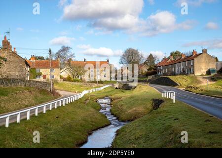 Das malerische Dorf Hutton-le-Hole in North Yorkshire liegt im North York Moors National Park, wo Schafe frei herumlaufen können. Stockfoto