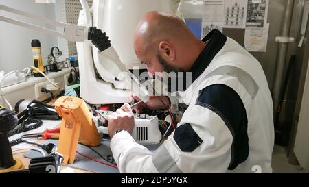 Elektriker Messungen mit Multimeter-Tester - Elektroniker arbeiten an Reparatur LED Nachtclub Moving Head Light Stockfoto