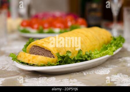 Hackbraten mit Käse und Salatblättern auf dem Tisch für Neu Jahr und Weihnachten Stockfoto