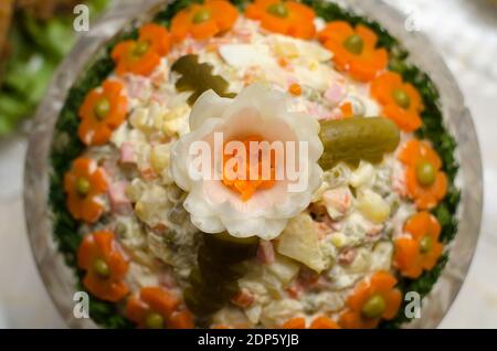 Wunderschön gestalteter Olivier-Salat mit Zwiebelrosette für Neujahr und Weihnachten, Draufsicht, Nahaufnahme Stockfoto