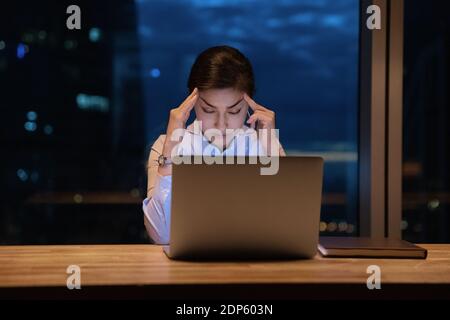 Müde indische weibliche Angestellte schlafen am Arbeitsplatz ein Stockfoto