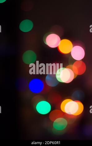 Abstrakt farbige Bokeh Hintergrund von verschwommenen Lichtern Girlande auf schwarzem Hintergrund, für Weihnachten, Neujahr und Feiertage Stockfoto