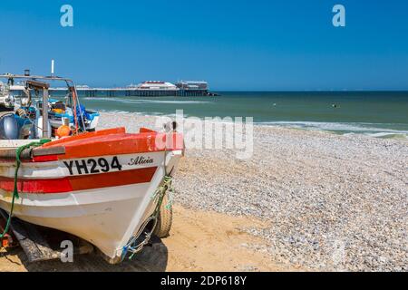 Blick auf Cromer Pier und Boote am Strand an einem Sommertag, Cromer, Norfolk, England, Vereinigtes Königreich, Europa Stockfoto