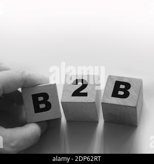 B2B Abkürzung in Buchstaben auf Holzwürfeln. Business to Business Concept Hand Legen Sie einen Würfel B in die Reihe. Konzept der Geschäftsmarketing-Strategie. Stockfoto
