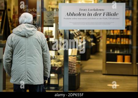 Braunschweig, Deutschland. Dezember 2020. Ein älterer Mann steht vor einer Parfümerie, an deren Eingang eine Notiz mit der Aufschrift 'Despite Lockdown - Pick Up in Store' steht. Seit 16.12.2020 gibt es strengere Regeln zur Eindämmung des Coronavirus. Quelle: Swen Pförtner/dpa/Alamy Live News Stockfoto