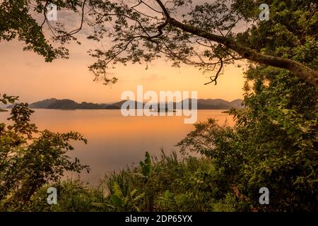 Lake Mutanda bei Sonnenuntergang mit Blick auf die Vulkane Mount Muhavuru und Mount Gahinga in Ostafrika, entlang der Grenze von Ruanda und Uganda. Stockfoto