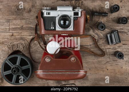 Retro-Kamera in einem braunen Lederetui liegt auf einem Holztisch. Draufsicht. Nostalgie Stockfoto