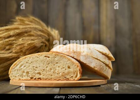 Frisches Brot in Scheiben auf einem Holzwandhintergrund Stockfoto