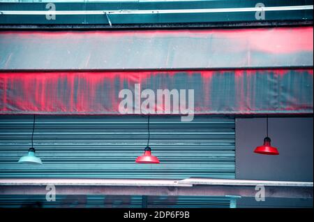 Sperre. Bunte Hängelampen hängen draußen an der geschlossenen Bar. Urbane Szene. Abstrakt grungy Lifestyle Hintergrund. Wirtschaftskrise, Renovierung, Verfall. Stockfoto