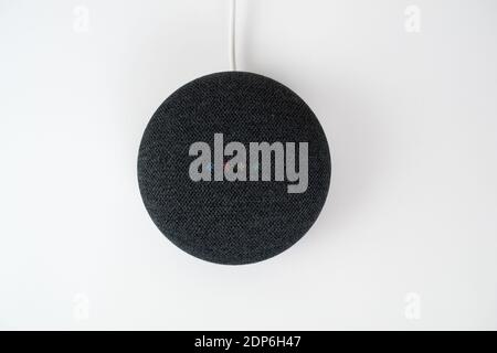 London, Vereinigtes Königreich - 19. Dezember 2020: Charcoal Google Nest Home Mini Smart Speaker mit eingebautem Google Assistant auf weißem Hintergrund. Stockfoto
