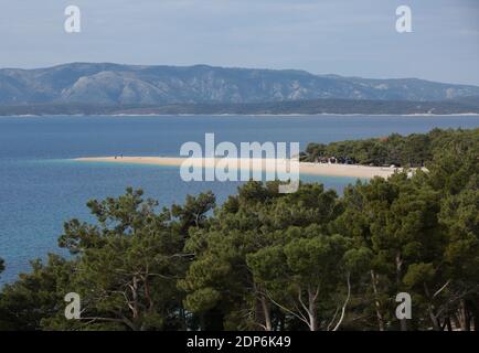 Erhöhter Blick über Baumkronen in Richtung Zlatni Rat, Bol, Insel Brac, Dalmatien, Kroatien, Europa. Stockfoto