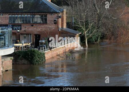 Hereford, Herefordshire - Samstag, 19. Dezember 2020 - Arbeiter beeilen sich, zusätzliche Hochwasserschutzmaßnahmen an der Wand eines Pub am Flussufer zu errichten, da der Fluss Wye nach mehreren Tagen starken Regens voraussichtlich auf 4,8 m steigen wird. Der Pub pumpt bereits Wasser aus seinen Kellern. Foto Steven May / Alamy Live News Stockfoto