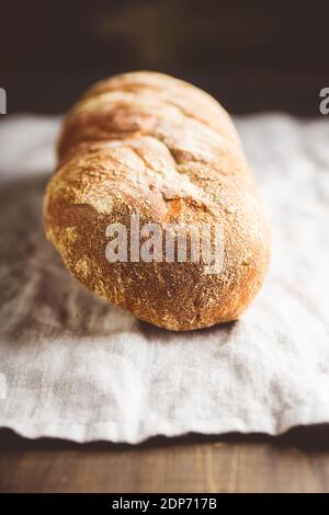 Frisch gebackenes Brot auf dem alten Holztisch. Selektiver Fokus. Geringe Schärfentiefe. Stockfoto