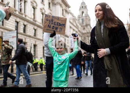 Ein Kind, das während des COVID-19 Anti-Impfstoff-Protests mit einem Plakat marschierte, Westminster, London, 14. Dezember 2020 Stockfoto