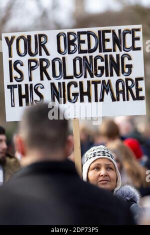 Frau mit Plakat während des COVID-19 Anti-Impfstoff-Protests, Westminster, London, 14. Dezember 2020 Stockfoto