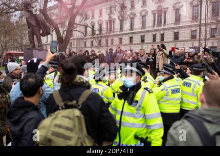 Die Polizei versucht, die Menschenmenge während des COVID-19 Anti-Impfstoff-Protests, Parliament Square, London, 14. Dezember 2020, zu kontrollieren Stockfoto