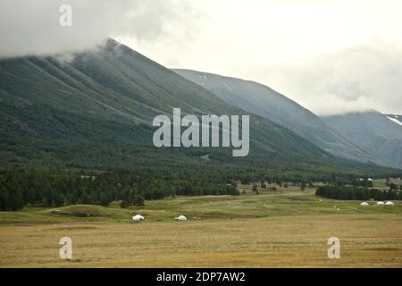 Eine wunderschöne Landschaft umgeben von Bergen, die unter der Wolken glänzen Himmel Stockfoto