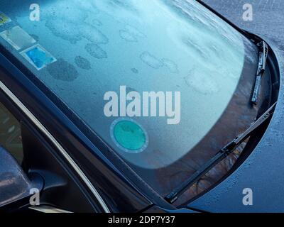 Gefrorener Rückspiegel und Scheibenwischer des Autos mit Eiszapfen