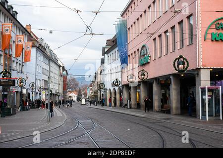 Freiburg, Deutschland. Dezember 2020. In der Nähe des Bertoldsbrunnens wandern die Menschen durch die Innenstadt. Die Landesregierung Baden-Württemberg hat im Rahmen einer harten Sperre, der Bund und Länder bundesweit zugestimmt haben, teilweise Sperrungen zur Eindämmung des Coronavirus auferlegt. Quelle: Philipp von Ditfurth/dpa/Alamy Live News Stockfoto