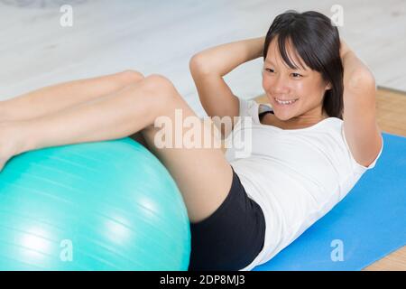 Frau mit einem Übungsball in ihrem Haus Stockfoto
