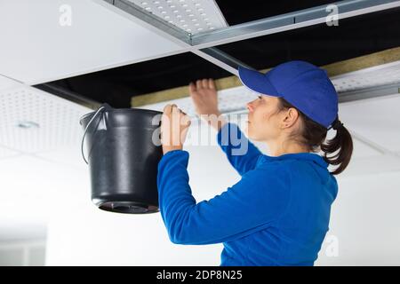 Gestresste Brünette Frau Umgang mit Wasserschäden in der Küche Stockfoto