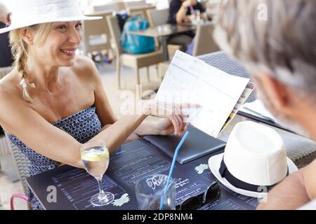 Nette, glückliche Frau, die auf die Speisekarte des Restaurants zeigte Stockfoto