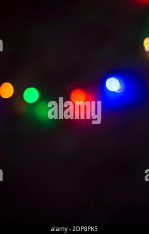 Die farbigen Lichter sind nicht fokussiert. Bokeh mehrfarbig auf schwarzem Hintergrund. Vorlage für Grußkarten Text. Stockfoto