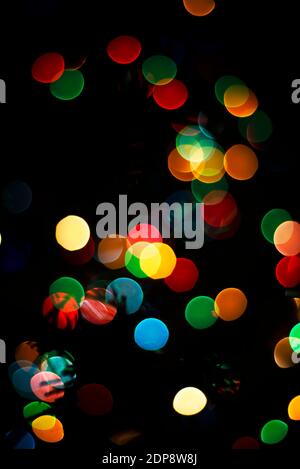 Die farbigen Lichter sind nicht fokussiert. Bokeh mehrfarbig auf schwarzem Hintergrund. Themen des neuen Jahres. Vorlage für Grußkarten Text. Stockfoto
