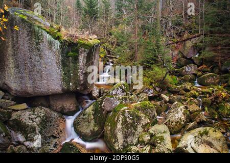 Herbst lange Exposition von Creek und Schwarz (Big) Stolpich Wasserfälle in Iser Gebirge. Das Wasser fällt in einen tiefen Wald Canyon voll Granit Steine Stockfoto