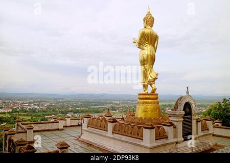 Unglaubliches goldenes Buddha-Bild in Walking-Haltung überblickt die Stadt Nan, Wat Phra, dass Khao Noi Tempel im Norden Thailands Stockfoto