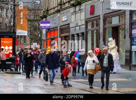 Dundee, Tayside, Schottland, Großbritannien. Dezember 2020. UK Wetter: Kühles und nasses Wetter in Nordostschottland mit Temperaturen bis 8 Grad Einige Käufer tragen Gesichtsmasken, während andere ohne Gesichtsschutz zusammen entlang der High Street im Stadtzentrum mit Einkaufstaschen und Geselligkeit unterwegs sind, während Dundee Tier 3 Covid-19 Lockdown-Beschränkungen erfährt, während die Coronavirus-Pandemie in der Tayside-Region andauert. Kredit: Dundee Photographics/Alamy Live Nachrichten Stockfoto