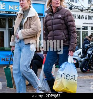 Epsom Surrey, London UK, 19.Dezember19 2020, Mutter und Teenage-Tochter, die durch einen Outdoor-Markt gehen und eine Next Fashion Retailer Shopping Bag in die Tasche ziehen Stockfoto