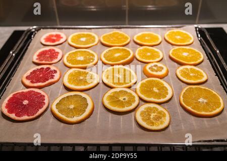 Orangen und Grapefruitscheiben auf einem Backblech zu sein Getrocknet für diy-Projekte und schöne Öko-Dekorationen Stockfoto