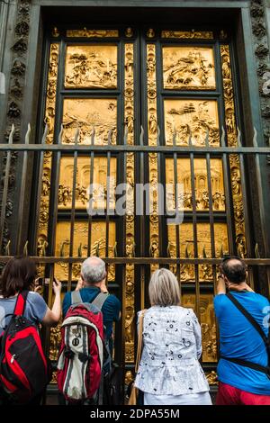 Die Menschen stehen vor den Toren des Paradieses, den Osttüren des Baptisteriums San Giovanni in Florenz und fotografieren. Ganz golden,... Stockfoto