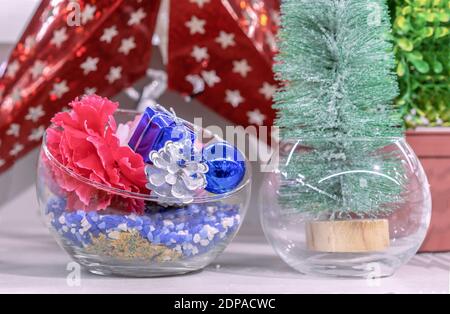 Glasvase mit Kieferkegel, Blume, Geschenk und blauer Weihnachtskugel. Neujahrsdekor. Stockfoto