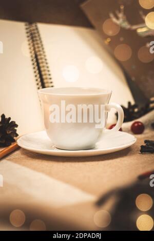 Gemütliche vertikale Zusammensetzung mit einer Tasse heißen Getränk, Abendessen, Bokeh und warmen Farbtönen Foto Stockfoto